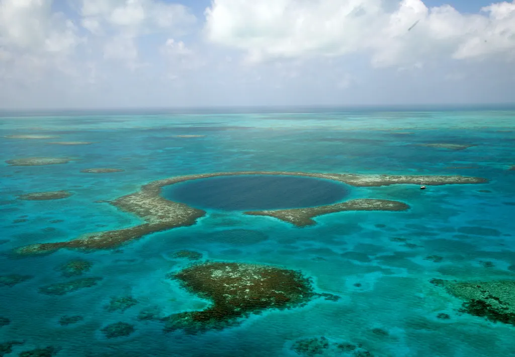 Aerial view of the Great Blue Hole, a dark blue circle in the turquoise reef of Lighthouse Reef, Belize